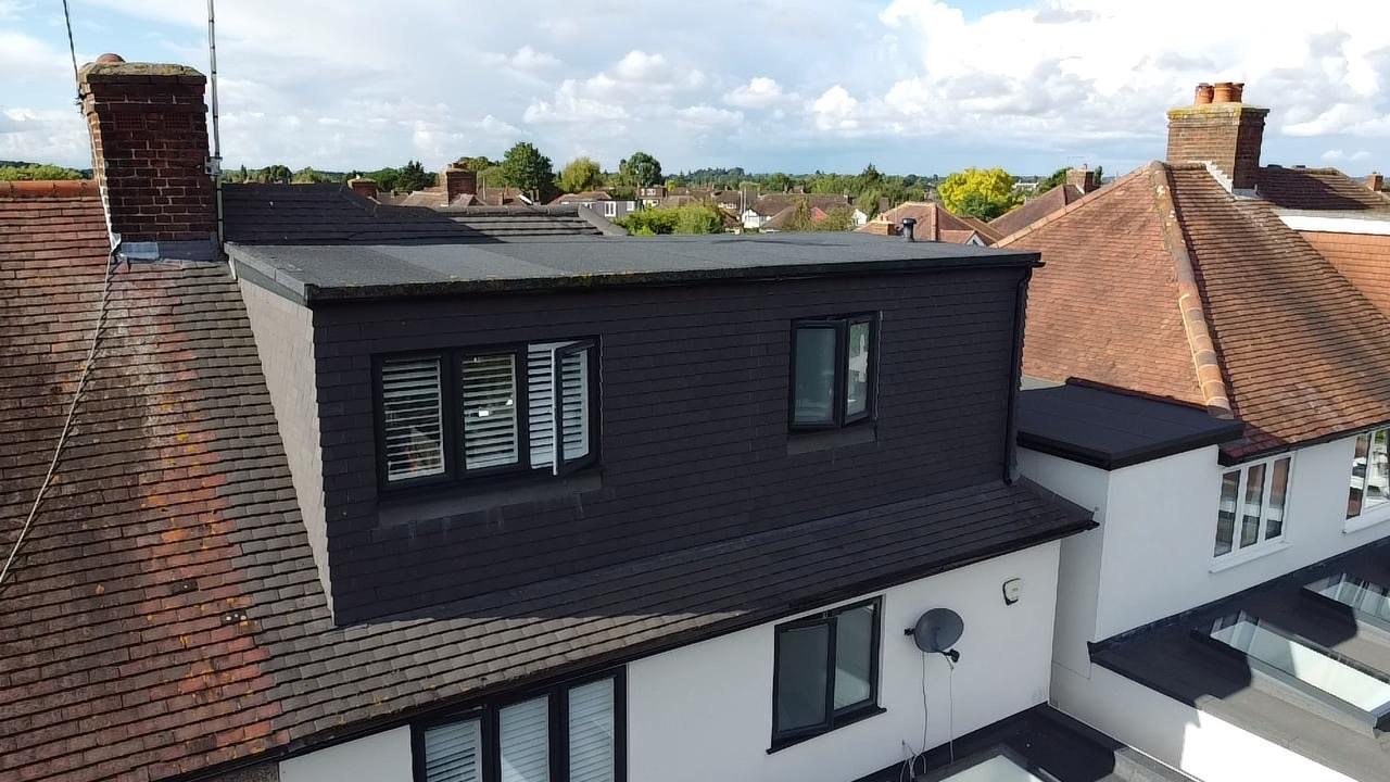 The finished dormer in sunlight, with shutters at the windows