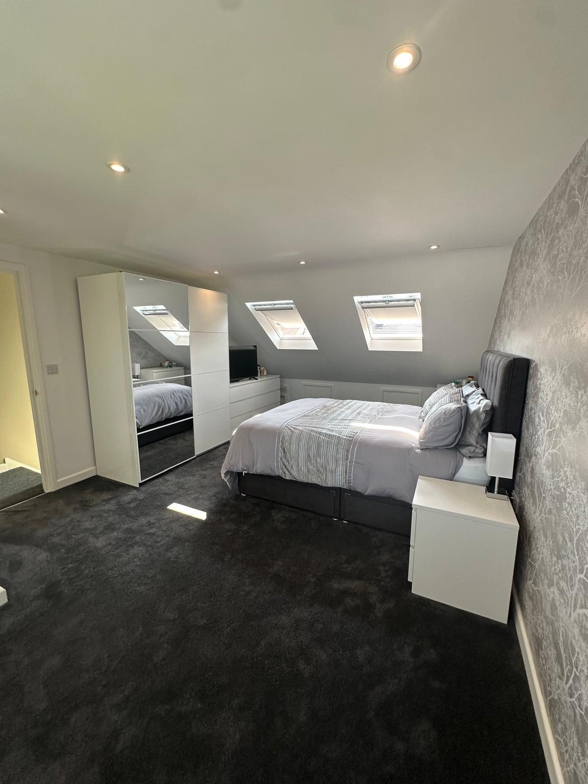 Loft bedroom with fitted mirrored sliding wardrobes