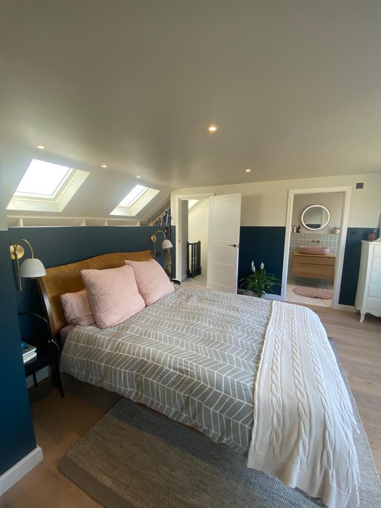 Loft bedroom with twin skylights and navy feature wall