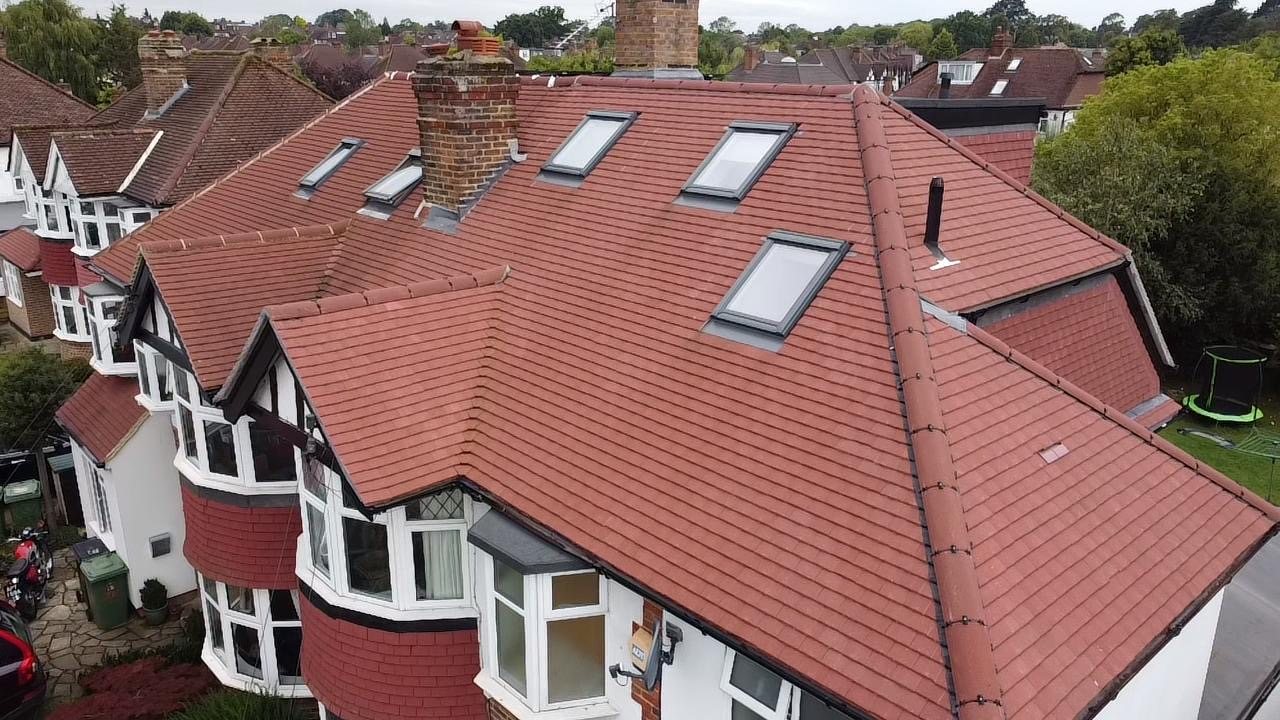 Re-roofed house with five new roof windows set into red clay tiles
